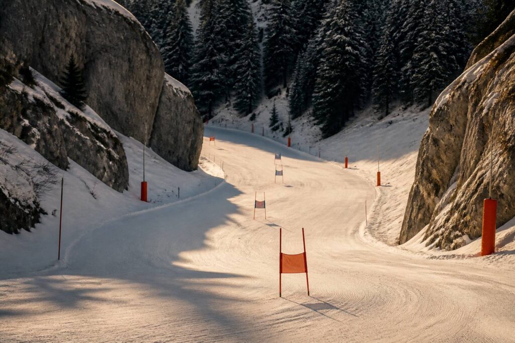 Piste de ski alpin entre deux parois rocheuses avec des portes de slalom plantées