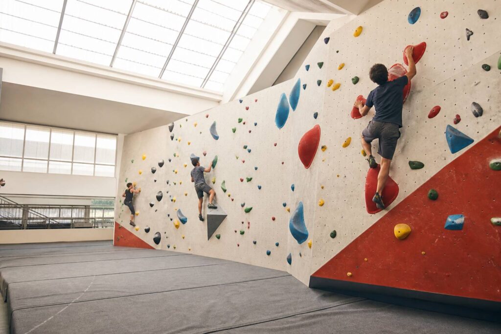 Mur d'escalade de bloc aux prises colorées dans une salle lumineuse et moderne