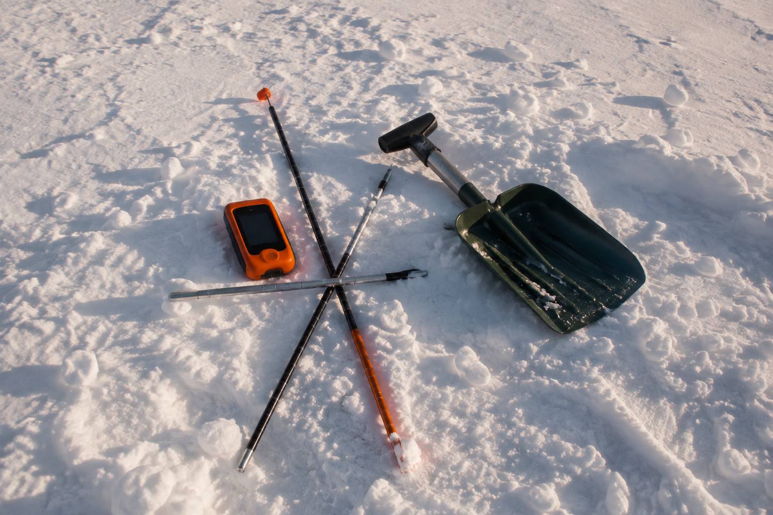 DVA, sonde et pelle disposés dans la neige pour illustrer la méthode de recherche